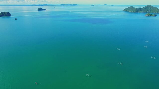 Drones are flying over the beautiful sea, many islands in the background, fish traps and squid traps on the sea, the fishing industry in Ao Kram, Chumphon, Southern Thailand. 4K drone footage

