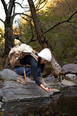 Naklejka premium woman in mountain and forest with hat and backpack autumn afternoon 