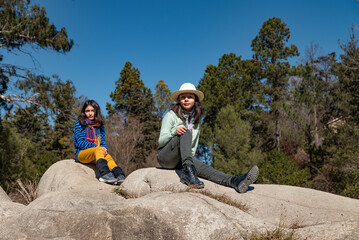 mujeres senderistas sentadas en rocas de montaña en primavera
