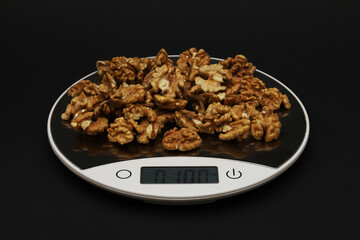 Walnut weighing 100 grams on electronic scales. Close-up
