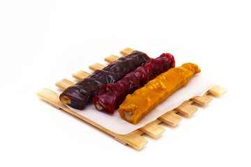 Pieces of churchkhela of different colors on a light background. Shallow depth of field