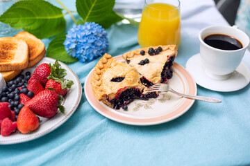 Cute breakfast with fruits and coffee in the garden, blue hydrangea flowers.
