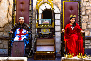 king and queen sitting on throne