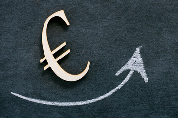 Rise in the euro exchange rate.growth of the exchange rate. Euro sign and up arrow on black chalk...