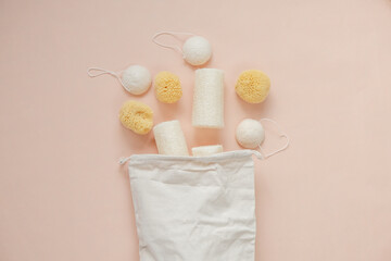 cognac sponges and loofah washcloths and a beige cotton bag on a beige light background.Eco...