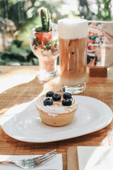 Lemon meringue and blueberry tart in white plate on wooden table. Pie Dessert. Horizontal Copy space