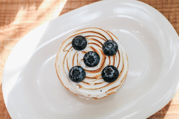 Lemon meringue and blueberry tart in white plate on wooden table. Pie Dessert. Horizontal Copy space