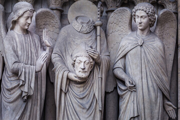 Saint Denis without head and angel, Notre dame detail, Paris, France - obrazy, fototapety, plakaty