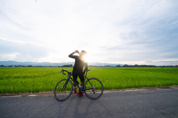 Obraz premium Cyclist is drinking water and look at the beautiful view while having a break