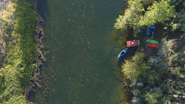 A kayaker getting into his boat for a and paddling down the Russian River in California - straight down aerial view