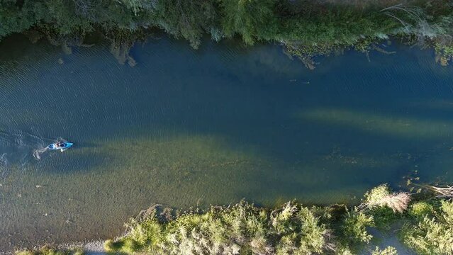 Single seat kayak maneuvering down the Russian River - a popular retreat for outdoorsmen living in central California - straight down aerial view