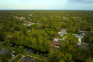 Fototapeta na wymiar Aerial landscape view of suburban private houses between green palm trees in Florida rural area