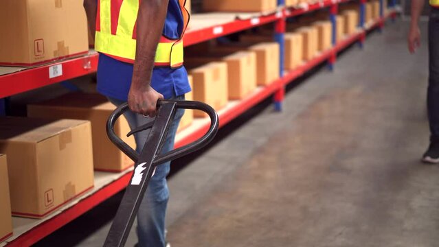 Warehouse staff pulling a pallet jack in the warehouse.