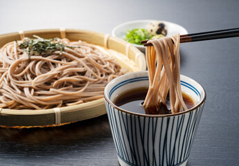 Zaru-soba placed on a black background. Soba noodles dipped in noodle soup.