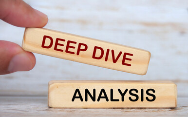Hand holding wooden blocks with text - Deep dive analysis.