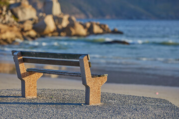 Relaxing bench with sea or ocean view to enjoy calm, peaceful and zen nature with waves washing on shore in a remote area. Scenic seating with blurred copy space in a coastal park on the promenade