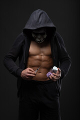 Muscular man with a syringe in his hand. Illegal user of anabolic steroids for strength training