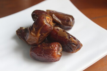 some dried dates on a white plate,