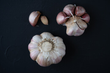 cabezas de ajo, con gajos sueltos sobre fondo negro cenital