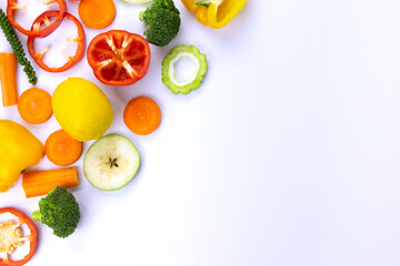 Mixed of Healthy food on white background, Natural colorful Healthy vegetarian fruits and vegetables, broccoli, sweet bell chili cut, carrot, green peppers, and lemon