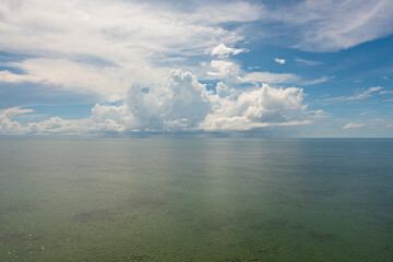 Tropical blue sea and blue sky with clouds. Seascape, aerial view. Flight over the sea.