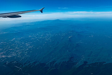 Fototapeta na wymiar View of blue cloudy sky from airplane window