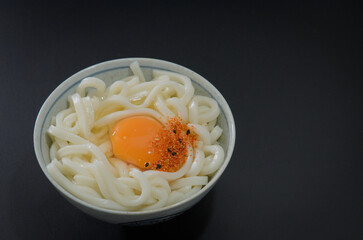 茹でたてうどんに卵と七味をのせて