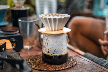 Drip coffee barista pouring water on coffee ground with filter