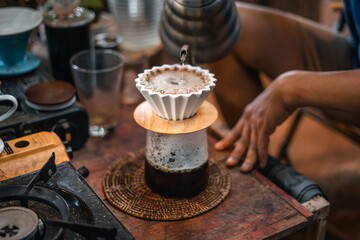Drip coffee barista pouring water on coffee ground with filter