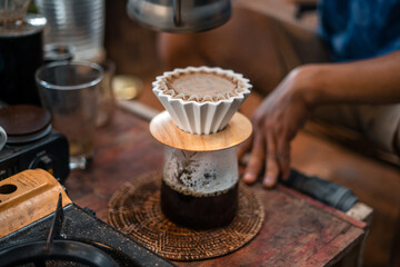 Drip coffee barista pouring water on coffee ground with filter