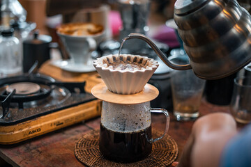 Drip coffee barista pouring water on coffee ground with filter