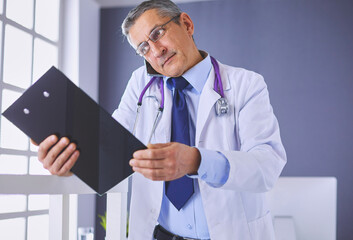 Male doctor writes notes on the clipboard in the hospital