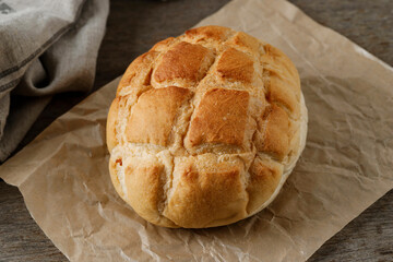 Homemade Boule Bread on Brown Paper, Rustic Wooden Table