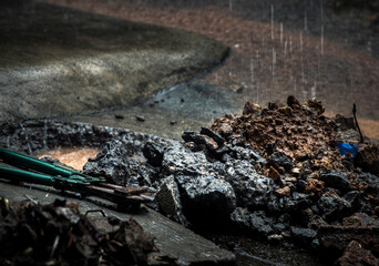 Broken leak water pipe busting at front of home during rain. Visible hole in the ground with Bolt...