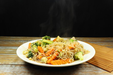 Traditional fried rice noodle mixed with fresh vegetable serving on the plate. Famous street food menu in Asia restaurant. High fiber and low fat recipe.
