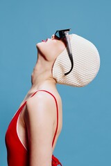 Elegant skinny stylish girl in a red swimsuit black glasses swimming cap raises her head up