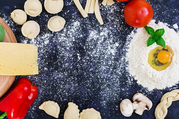 Raw pizza dough with ingredients and spices on dark background. Top view