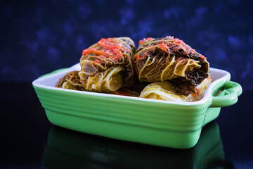 Cabbage rolls with savoy leaves on dark background