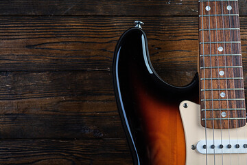 Close-up on electric guitar on vintage old wooden background
