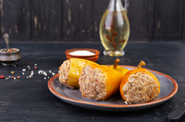 Colorful stuffed peppers with rice and minced meat on wooden background.