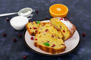 Cupcake with orange and cranberries on dark purple background