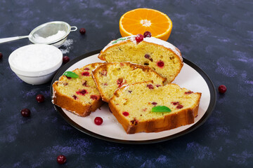 Cupcake with orange and cranberries on dark purple background