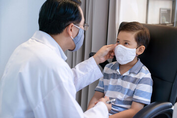 Fototapeta na wymiar Ophthalmologist examination child disorder, both wearing protective masks for disease prevention