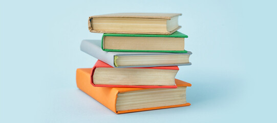 Stack of books on light blue background
