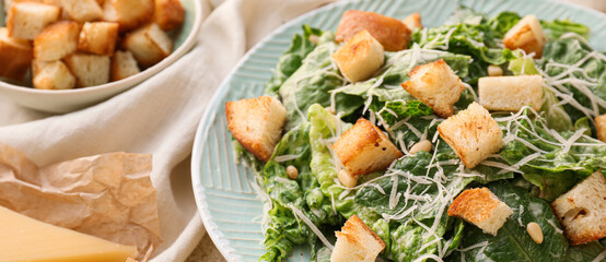 Plate with tasty Caesar salad on table, closeup