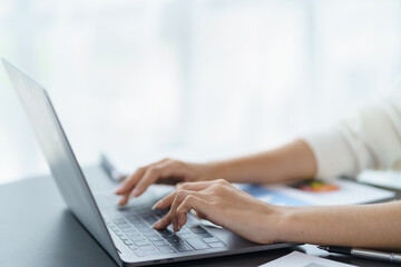 Close-up of business woman  typing on his laptop computer in the office.