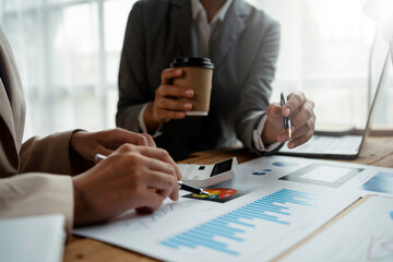Business people consulting and planning work, looking at chart growth details and thinking of new projects.