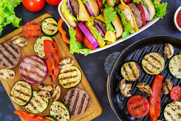 Fototapeta premium Grilled vegetables and handmade burger. Zucchini, eggplant, mushrooms, pepper on the grill. Top view