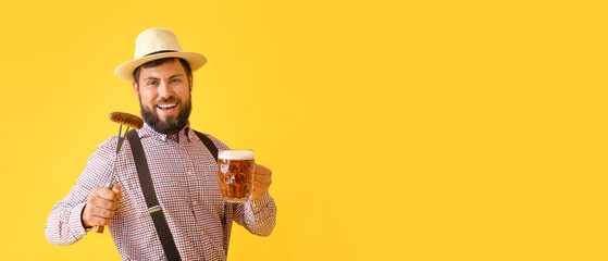 Handsome man in traditional German clothes, with beer and sausage on yellow background with space...