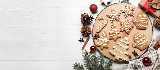 Board with Christmas gingerbread cookies on white wooden background with space for text